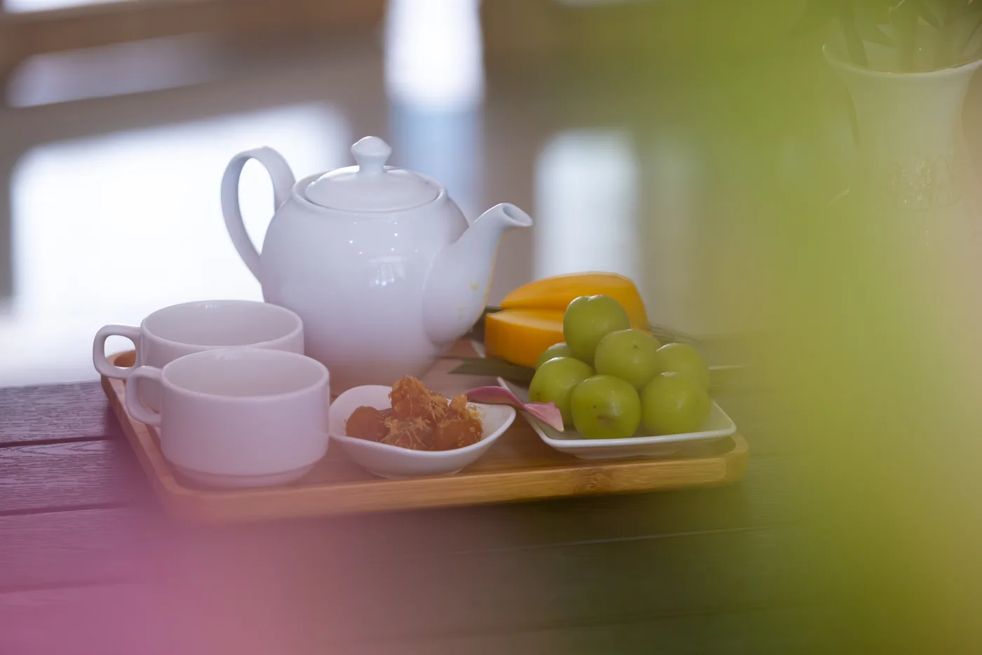 A teapot and fresh fruit prepared on a tray