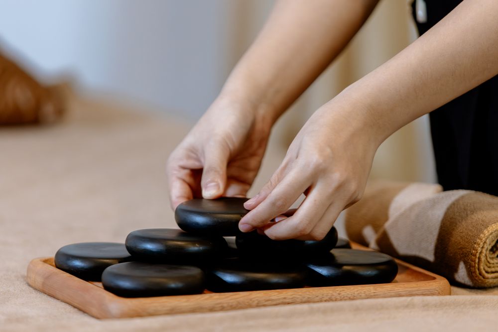 Warm massage stones carefully prepared by a Blue Sea Spa therapist